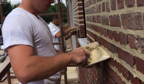 ouvrier réparant un mur un ravalement de façades