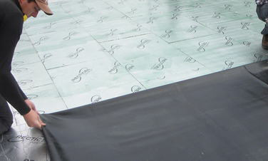 pose de rouleau de goudron sur une toiture terrasse