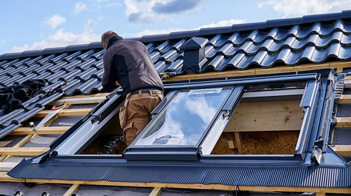 Ouvrier posant une fenêtres Velux