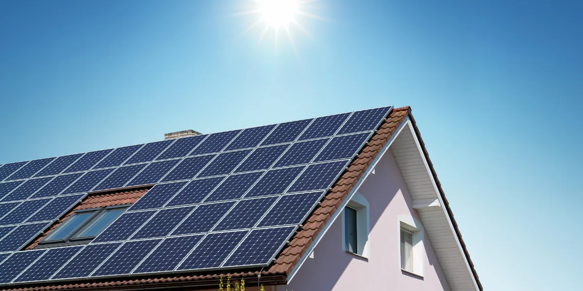 Toiture de maison équipée de panneaux solaires et de fenêtres de toit éclairant des combles aménagés
