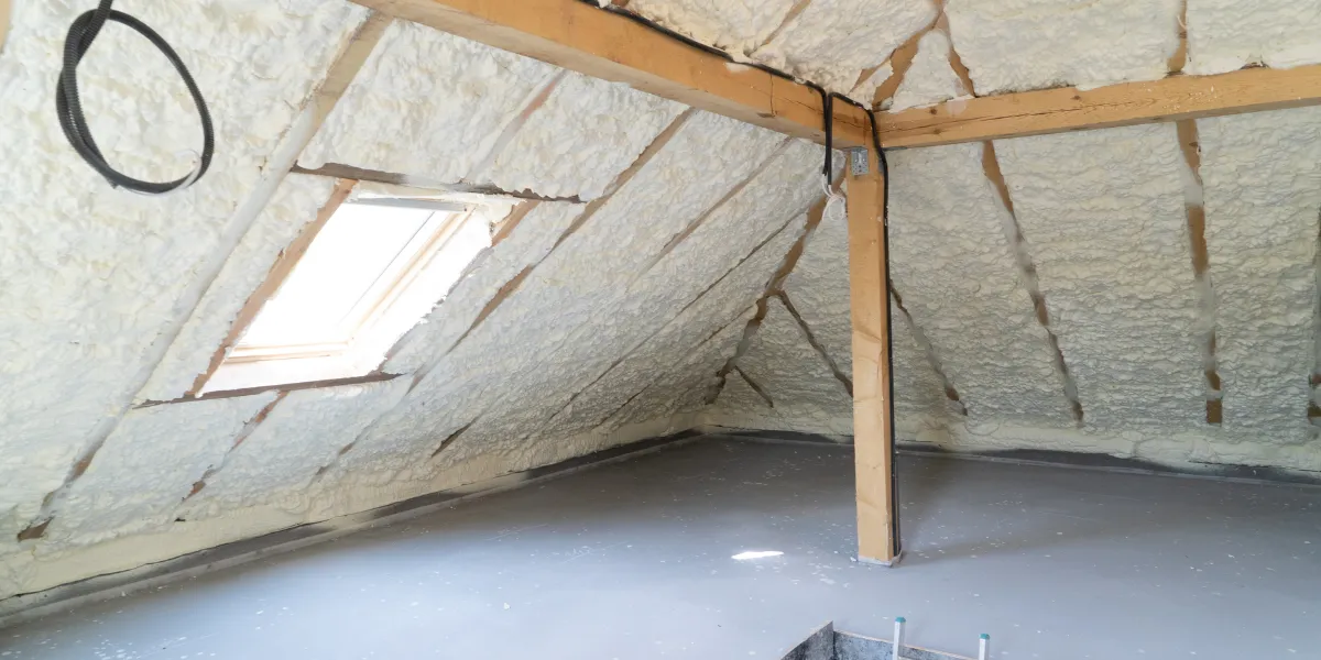 Technicien soufflant un isolant en vrac sur le plancher de combles perdus