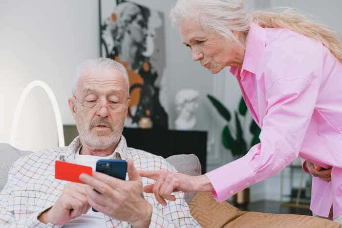 Couple de personnes âgées essayant de téléphoner