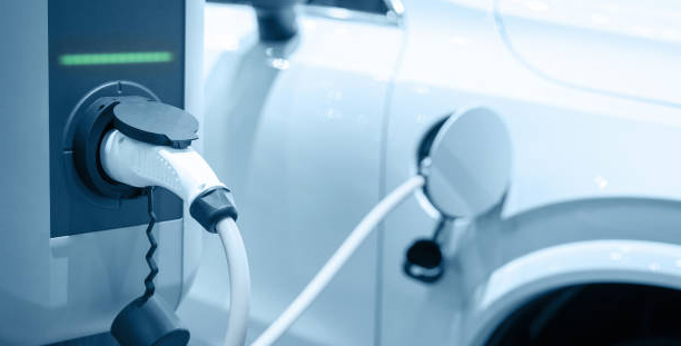 Voiture électrique en charge sur une borne alimentée par des panneaux solaires