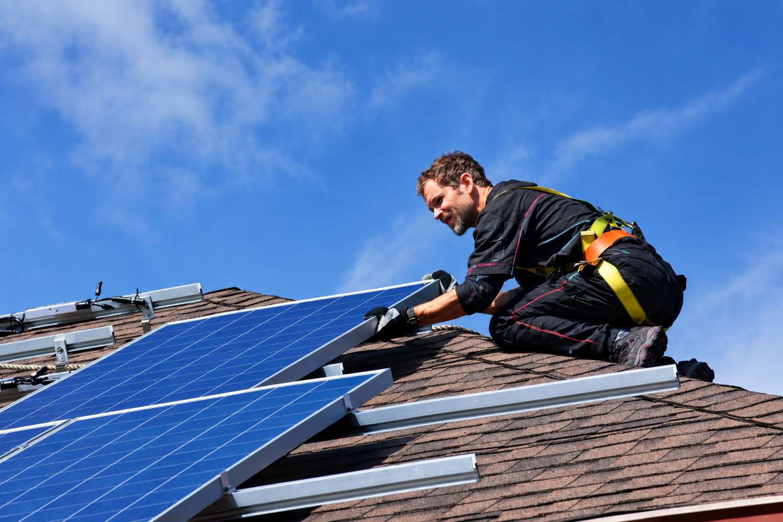 technicien posant un panneaux solaire sur un toit